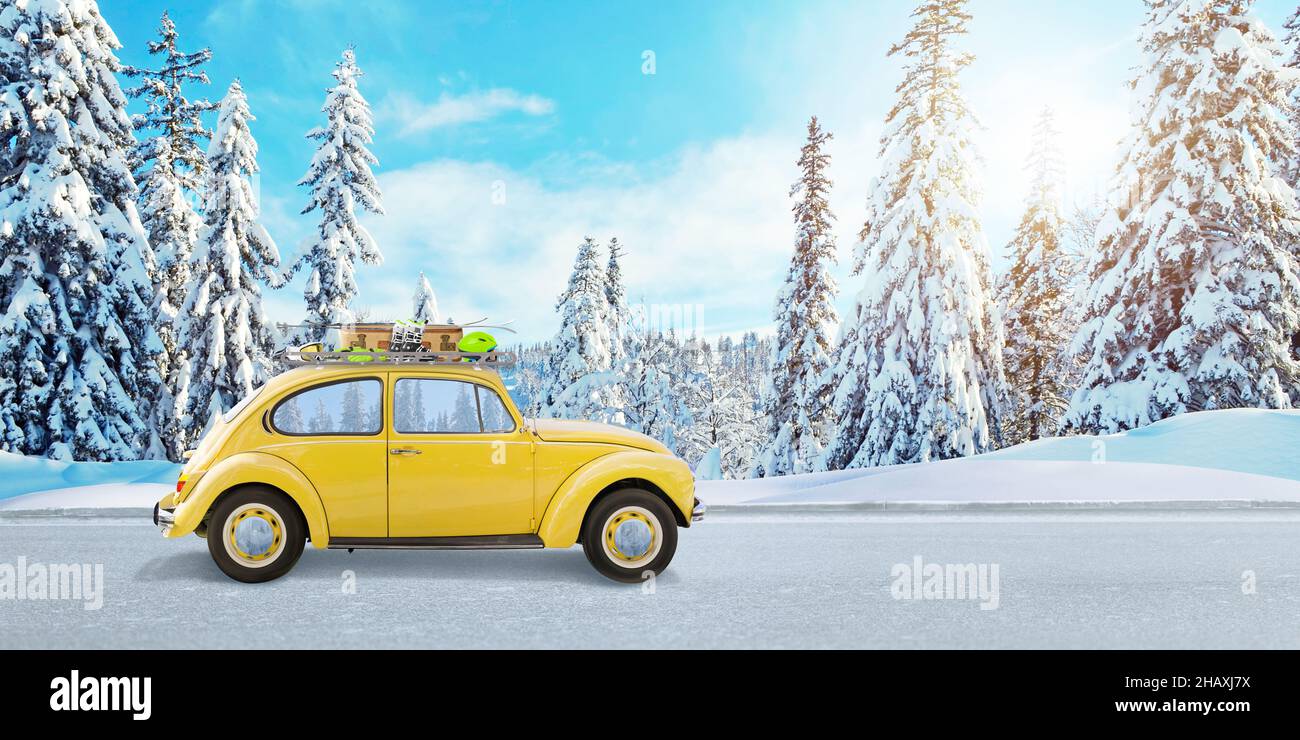 Auto gialla sulla strada con attrezzatura da sci. Il concetto di una vacanza invernale in montagna Foto Stock