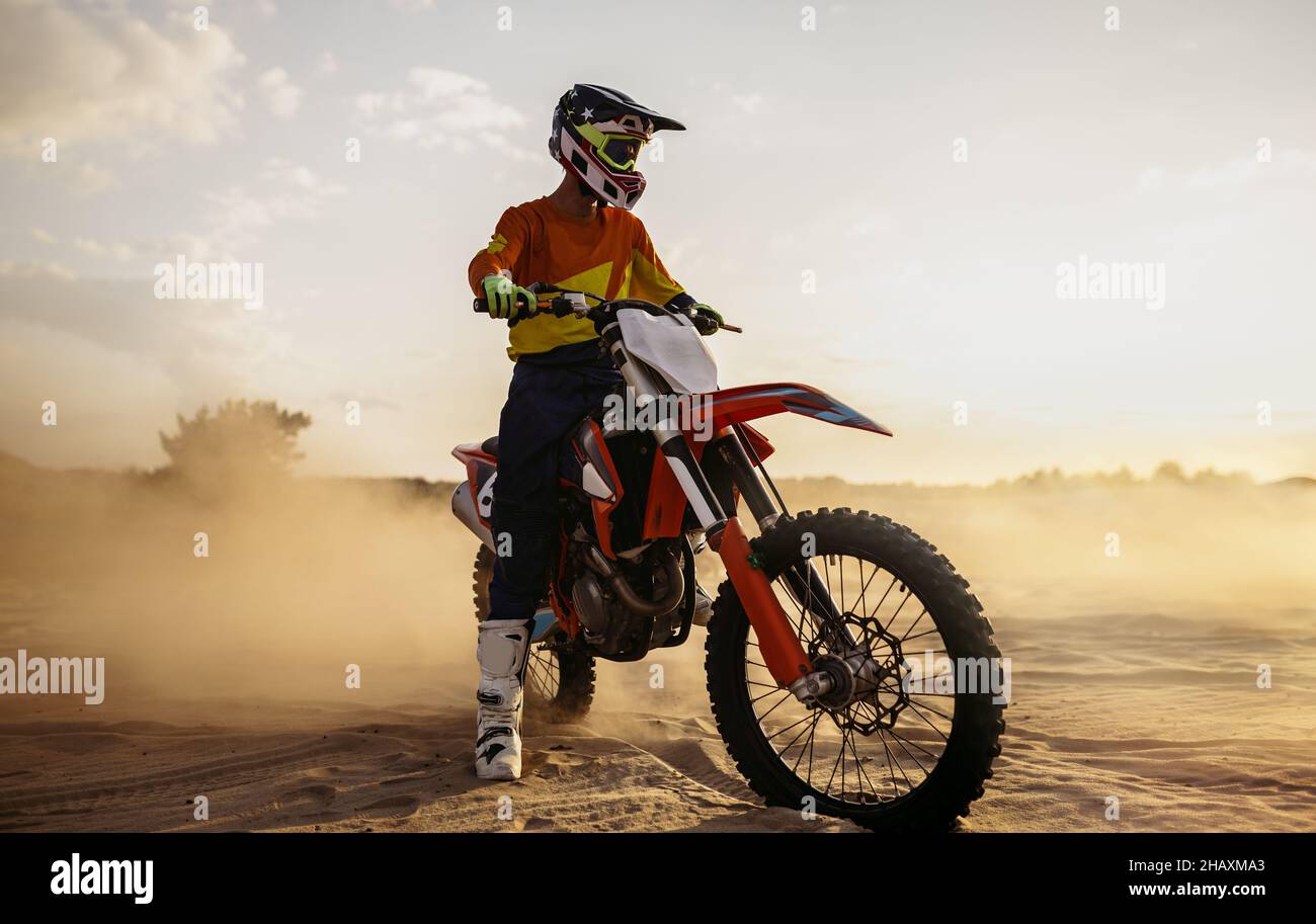 Pilota di motocross su motore sportivo su paesaggio polveroso Foto Stock