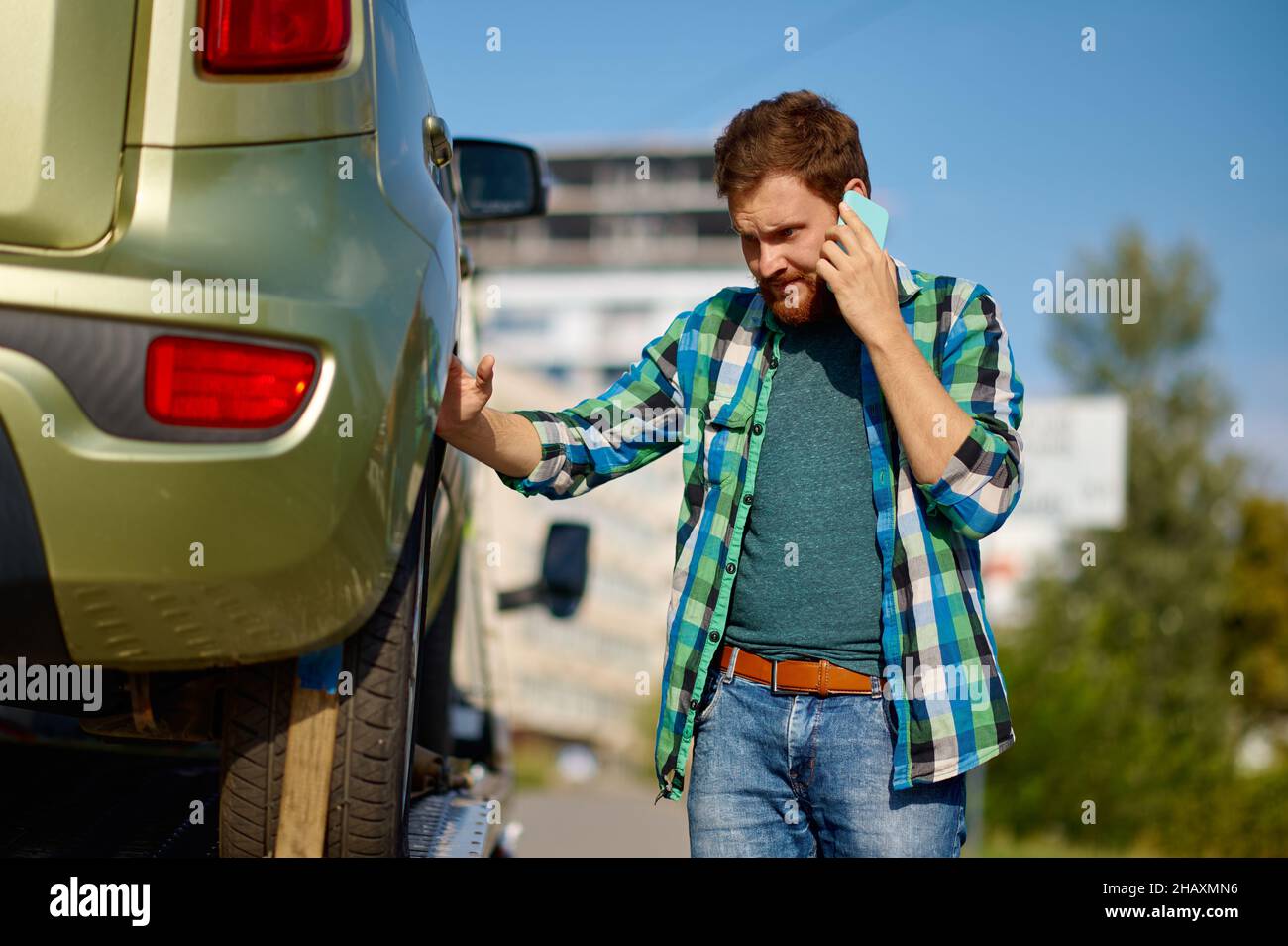 Uomo conducente che discute di avvenimento tramite telefono cellulare Foto Stock