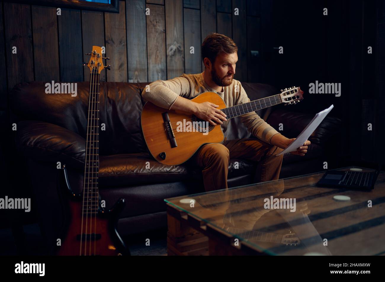 Giovane che impara a suonare la chitarra a casa Foto Stock