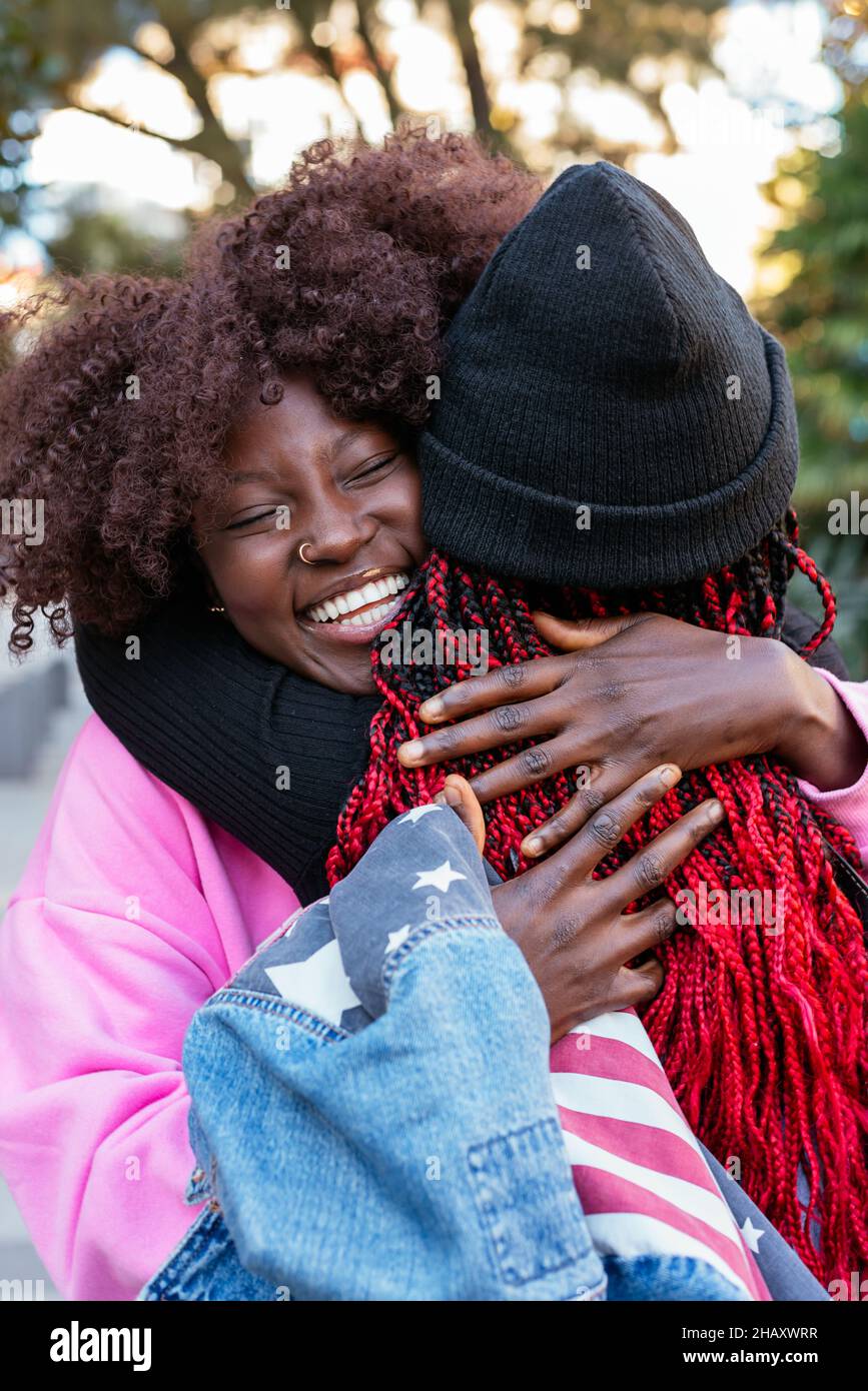 Giovani allegre amici afroamericani che si abbracciano mentre si trovano nel parco Foto Stock