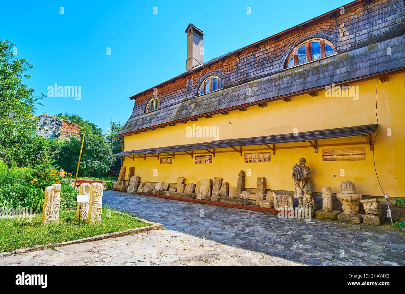 KAMIANETS, UCRAINA - 14 LUGLIO 2021: Il cortile della Magistrata russa con piccolo giardino e sculture e rilievi medievali danneggiati, decorarono il c Foto Stock
