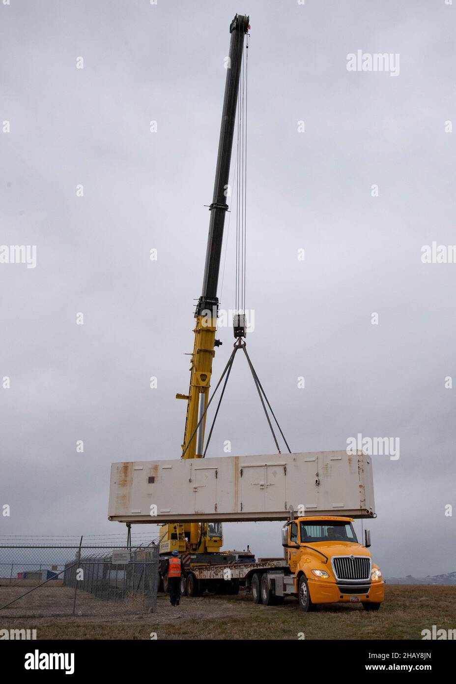 Un'azienda di gru appaltata solleva le vecchie strutture di stoccaggio il 13 dicembre 2021, presso la base della Guardia Nazionale aerea Roland R. Wright, Utah. Le strutture, che avevano più di 20 anni, erano state sostituite lo stesso giorno con edifici nuovi e migliorati. (STATI UNITI Air National Guard foto di Master Sgt. John Winn) Foto Stock