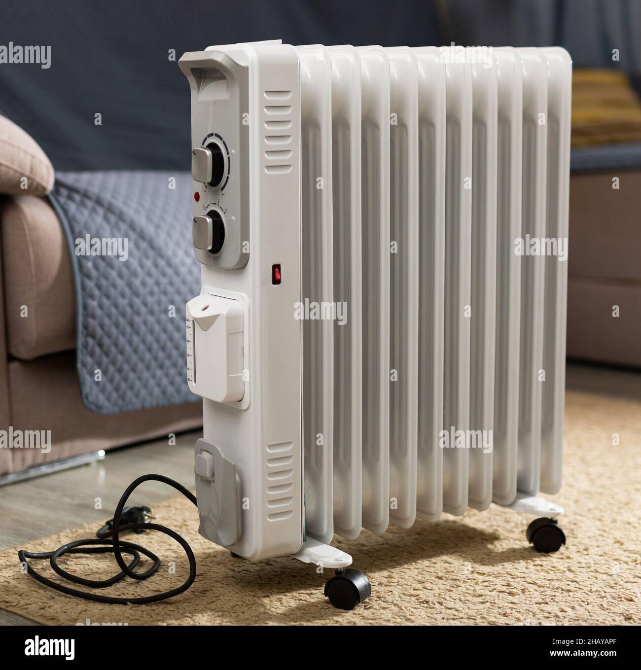 Radiatore elettrico a olio per il riscaldamento a casa in soggiorno Foto  stock - Alamy