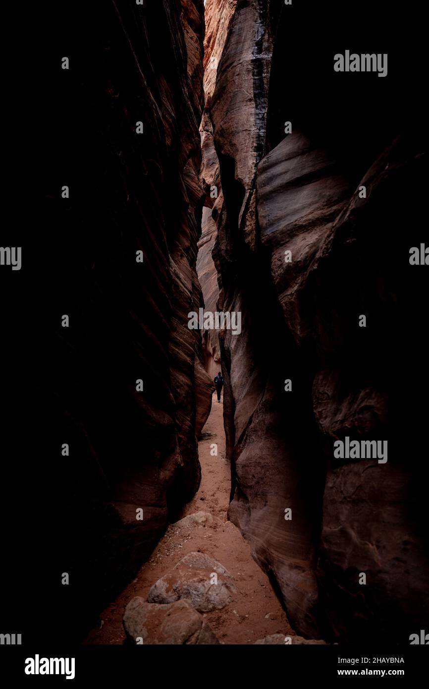 Escursionista lontano attraverso il Dark slot Canyon di Buckskin Gulch Foto Stock