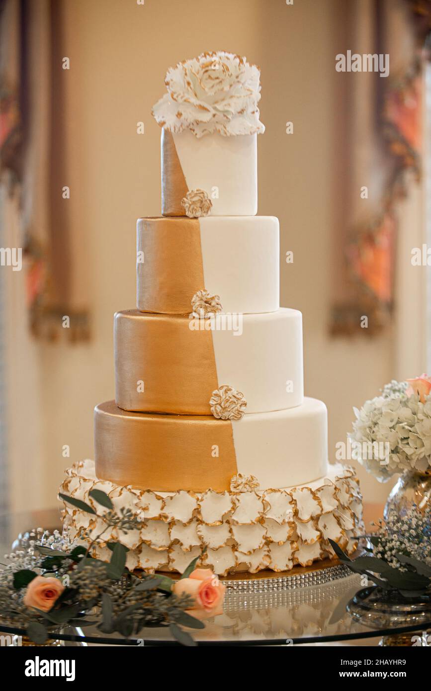 Splendida torta nuziale a cinque piani in oro e bianco al ricevimento nuziale Foto Stock