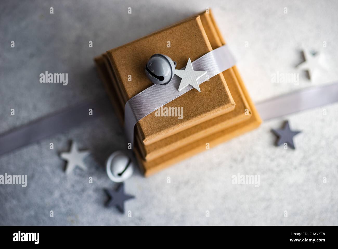 Vista dall'alto di tre scatole regalo con un nastro e campane di Natale e decorazioni a forma di stella Foto Stock