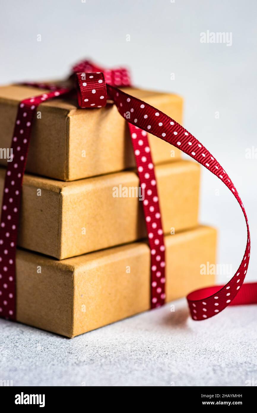 Pila di tre scatole regalo legate con un nastro rosso Foto Stock