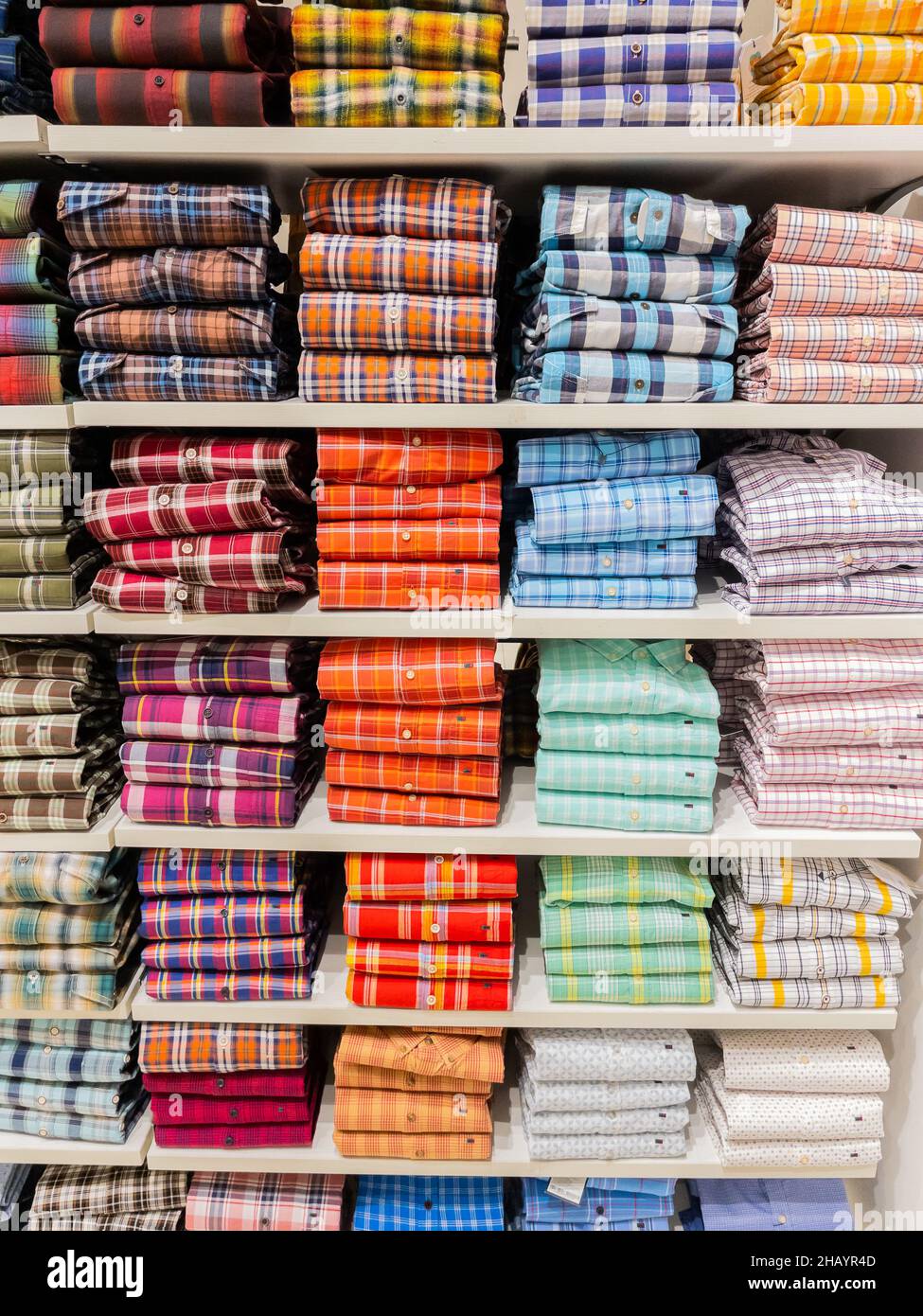Pile di colorati assegni modello camicie a maniche piene esposte sullo scaffale di un negozio al dettaglio a Pune Insia il 9 dicembre 2021 Foto Stock