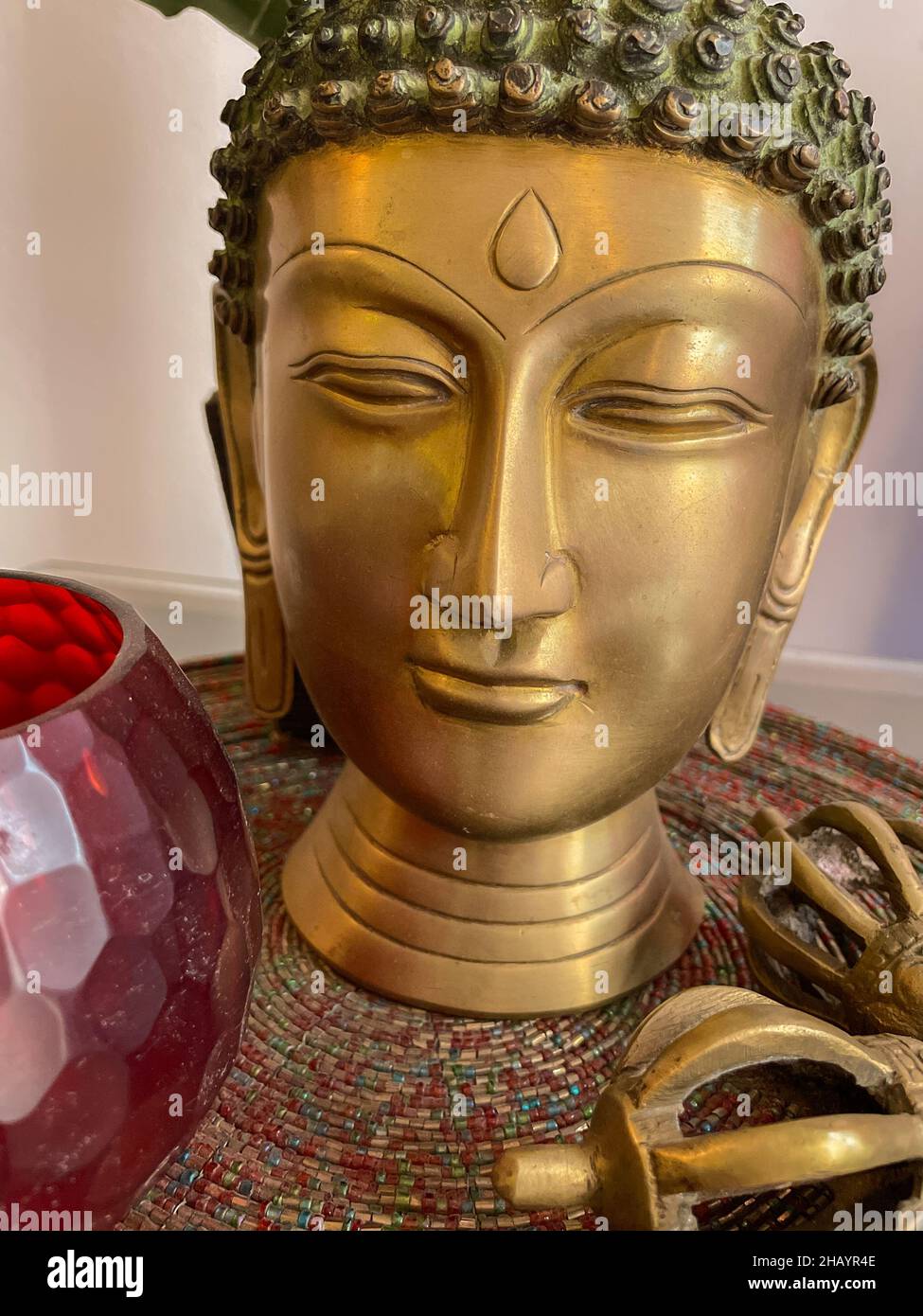Immagine ravvicinata del volto di Buddha in metallo posto su un tavolo Foto Stock