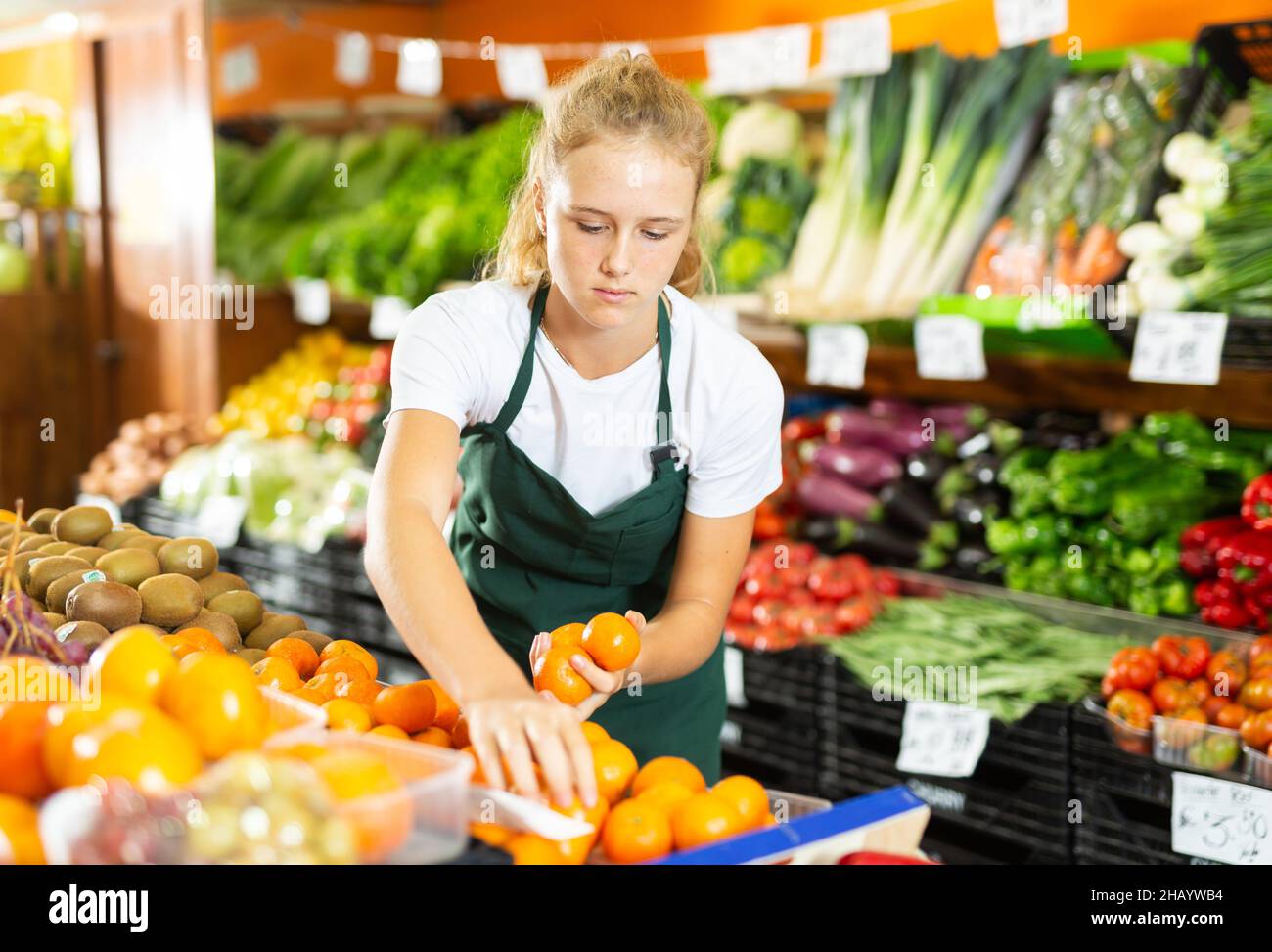 Ragazza al suo primo lavoro in negozio di verdure Foto Stock