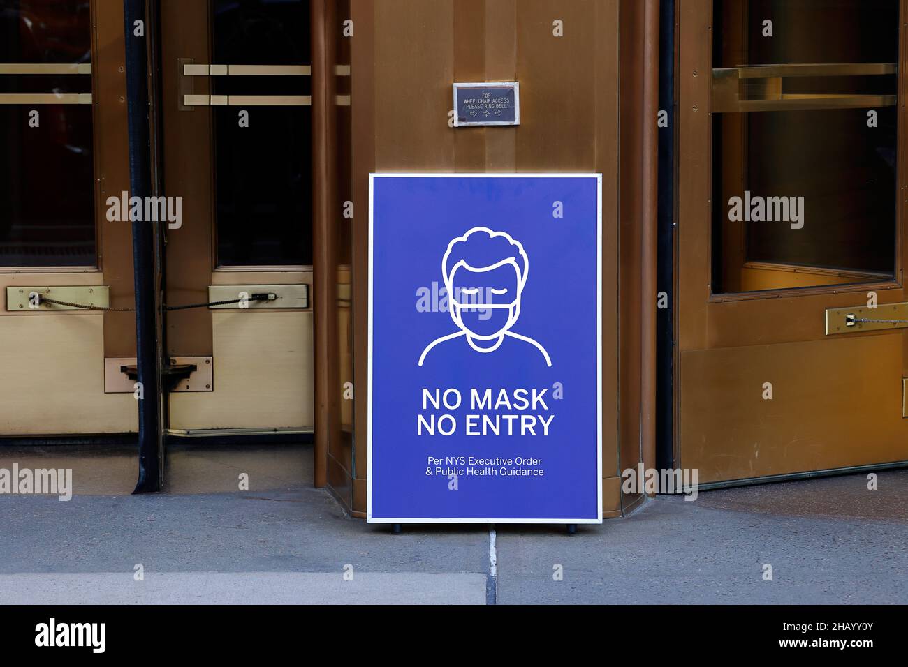 Cartello "No Mask, No Entry" sulla salute pubblica all'ingresso di un edificio di uffici a New York City. Foto Stock