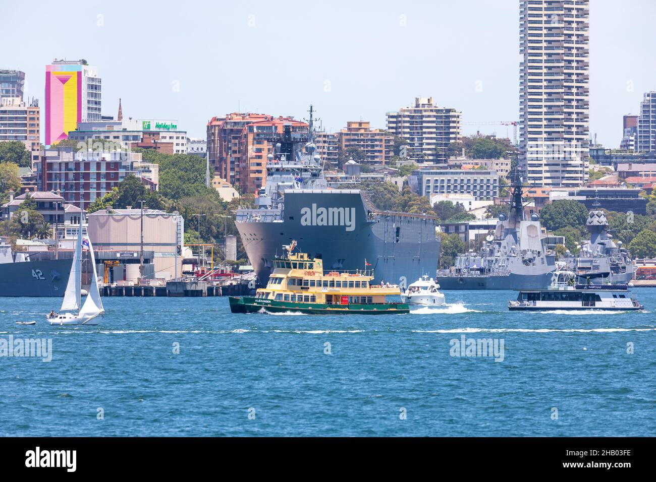 Sydney Ferry MV Alexander viaggia oltre la base navale australiana a Garden Island a Sydney e la nave navale HMAS Canberra, porto di Sydney, Australia Foto Stock