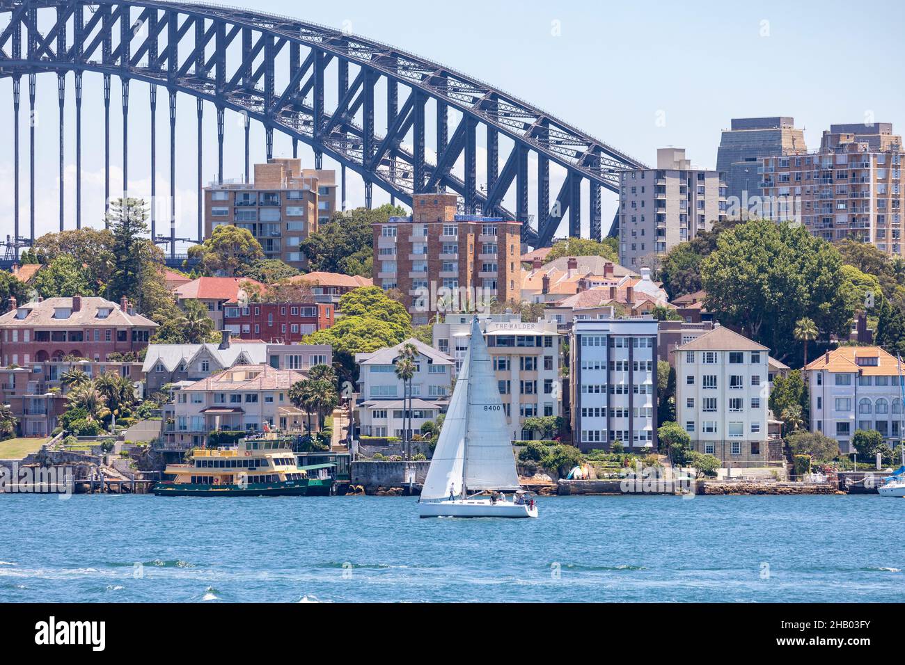 Barca a vela o Sydney Harbour di fronte alle case d'acqua a Kirribilli e il Sydney Harbour Bridge, sydney, Australia Foto Stock