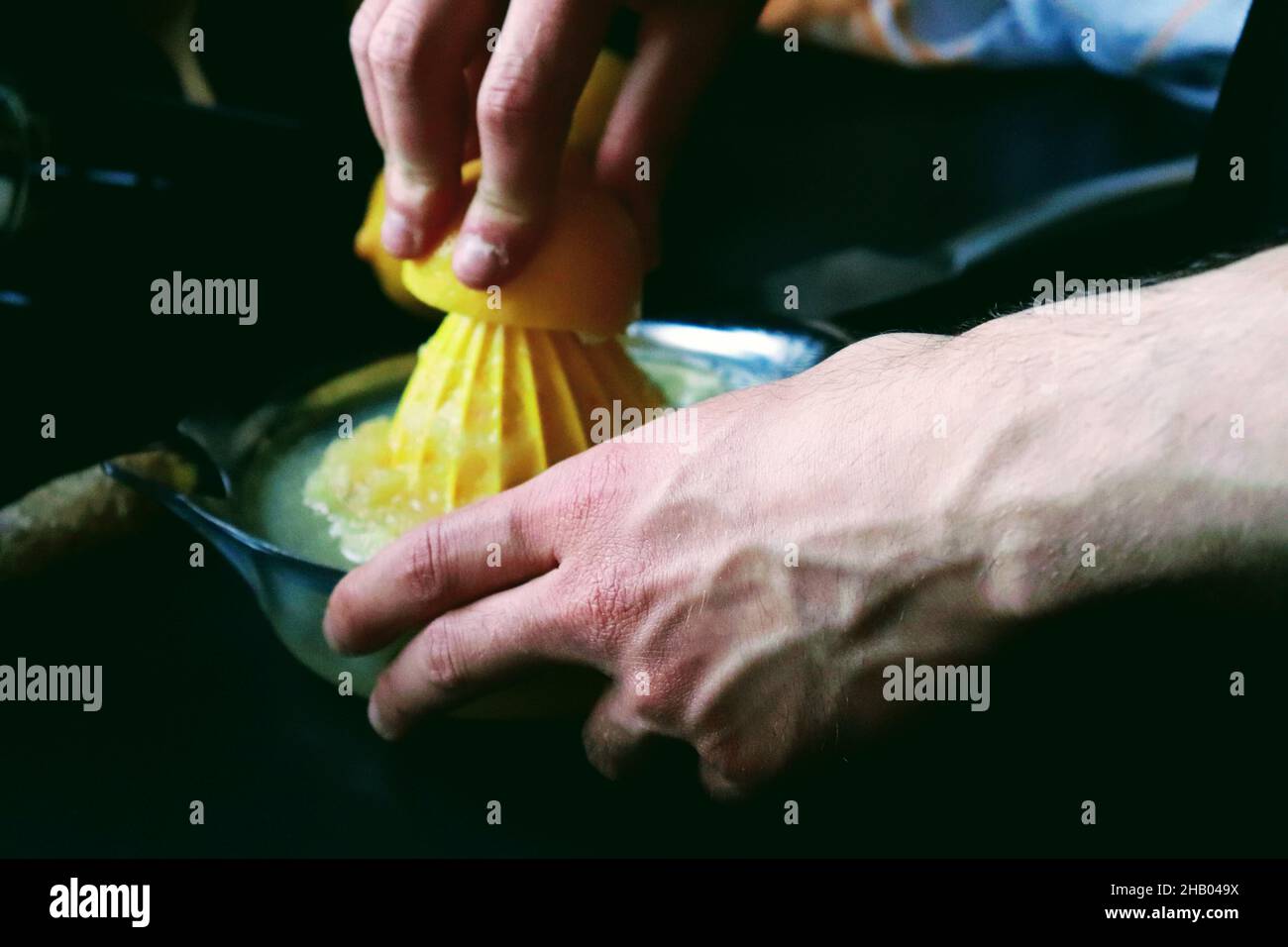 Closuep shot di un uomo le mani schiacciando limone in cucina Foto Stock