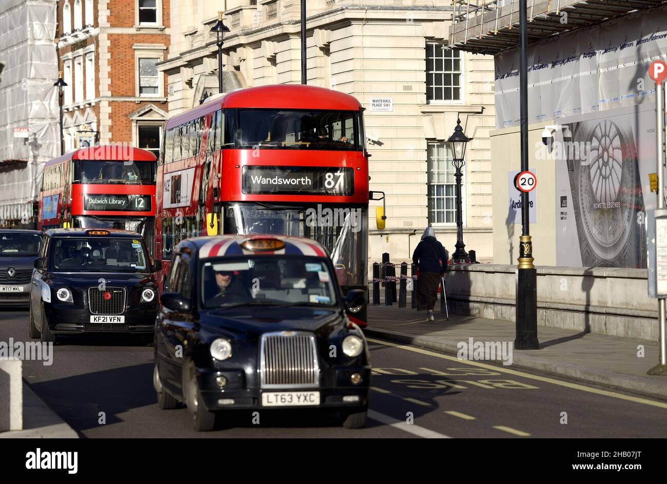 Londra, Inghilterra, Regno Unito. Autobus a due piani rossi e taxi neri a Whitehall Foto Stock