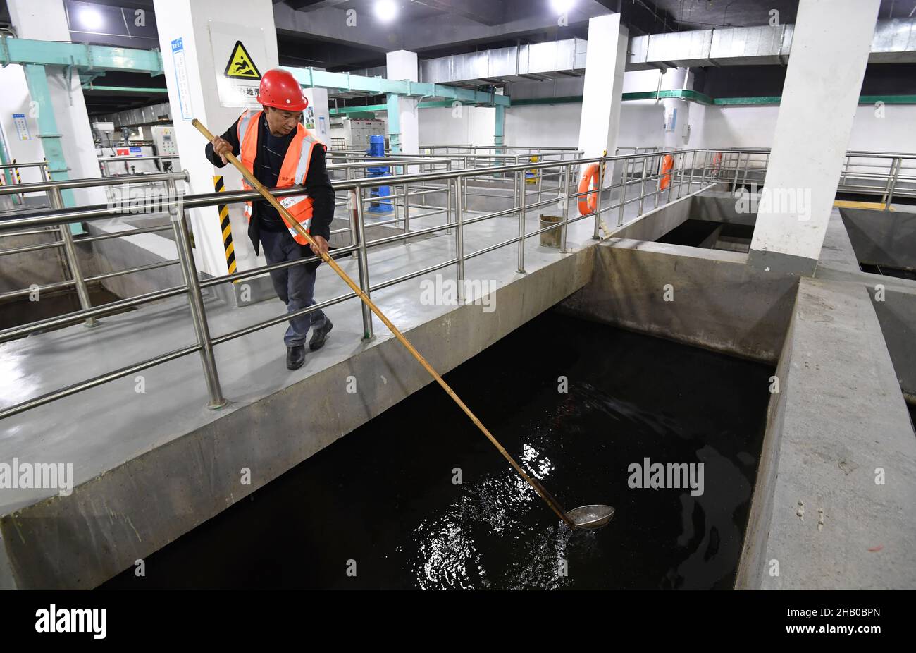 GUIYANG, CINA - 15 DICEMBRE 2021 - i pulitori di un impianto di riciclaggio dell'acqua pescano fuori la disattenzione da un serbatoio di sedimentazione ad alta efficienza il 15 dicembre 2021 in G Foto Stock