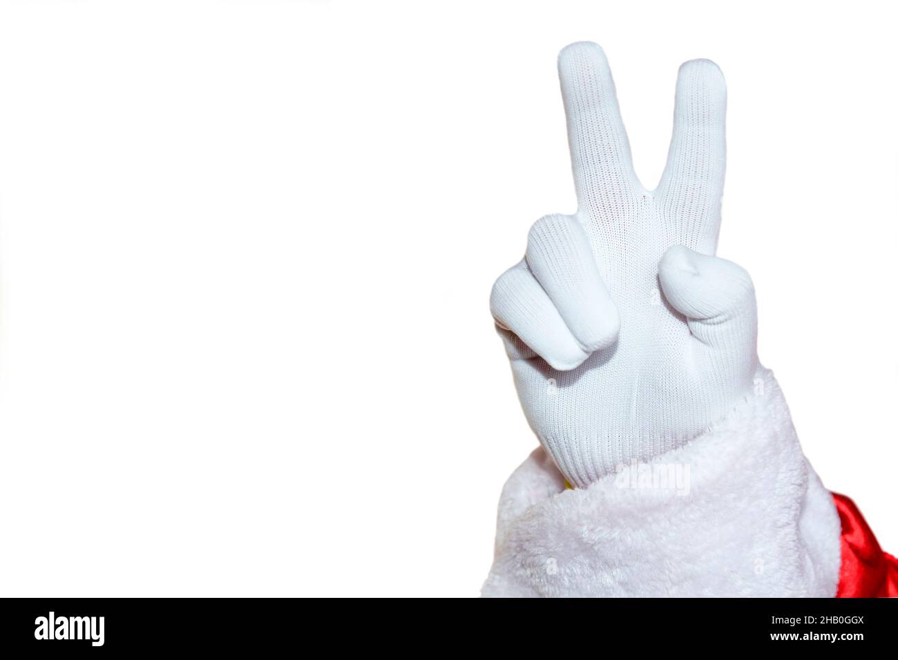 Una mano in un guanto bianco, due dita sollevate su uno sfondo bianco. Babbo Natale mostra un gesto positivo. Isolare. Foto Stock