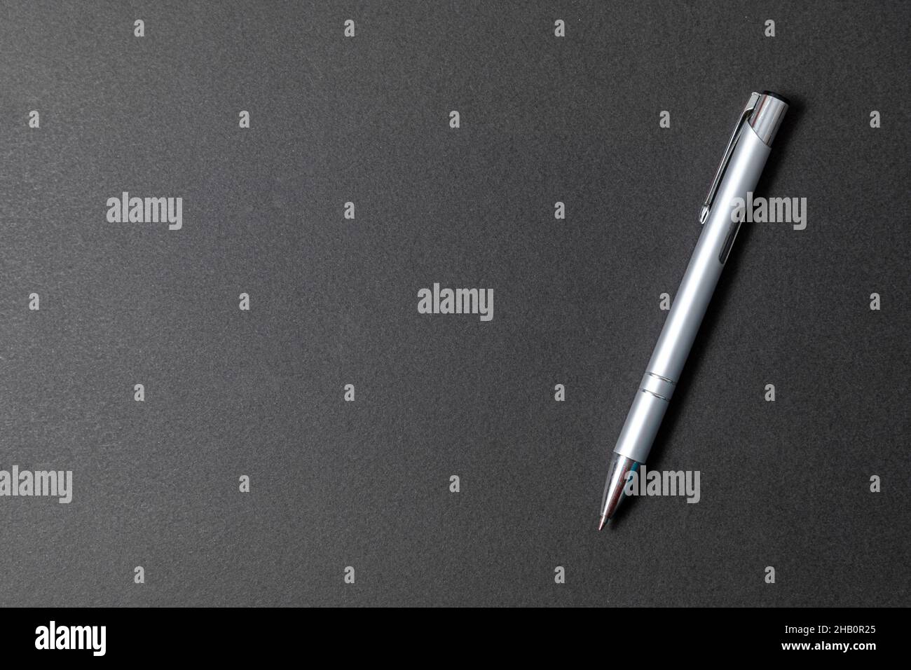 Elegante penna a sfera in metallo di lusso su sfondo di pietra nera Foto Stock