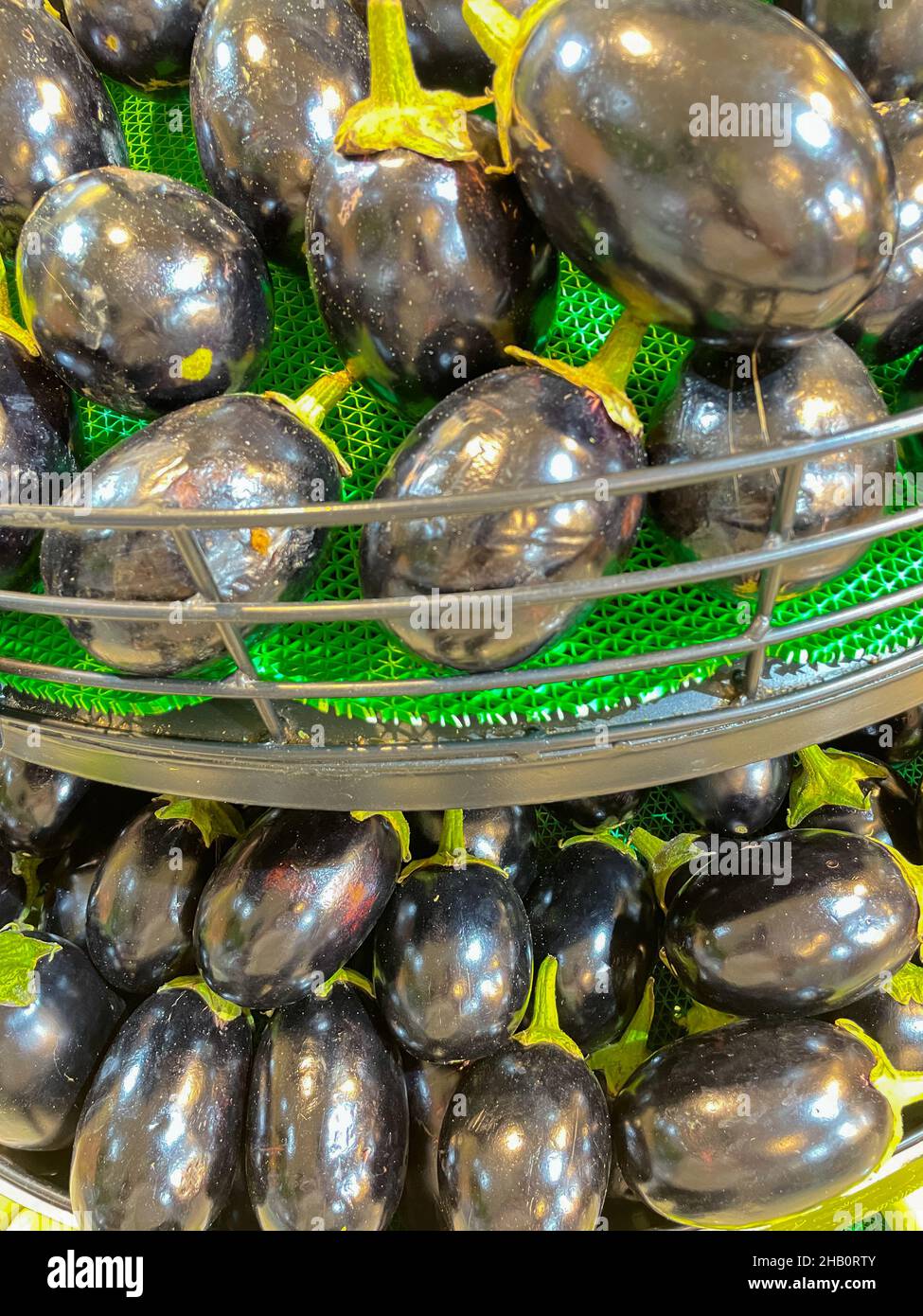 Eggplants freschi biologici chiamato anche Brinjal mantenuto in un cestino in un supermercato Foto Stock