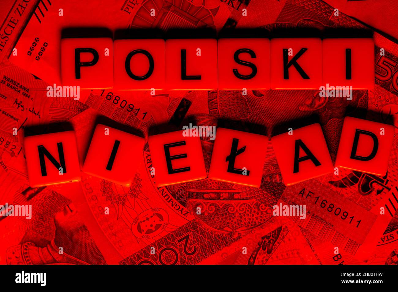 La frase 'Polski Ład' tradotta come 'Ordine Polacco' e molte banconote polacche. Nuove norme fiscali in Polonia. Foto scattata con luce rossa aggressiva. Foto Stock