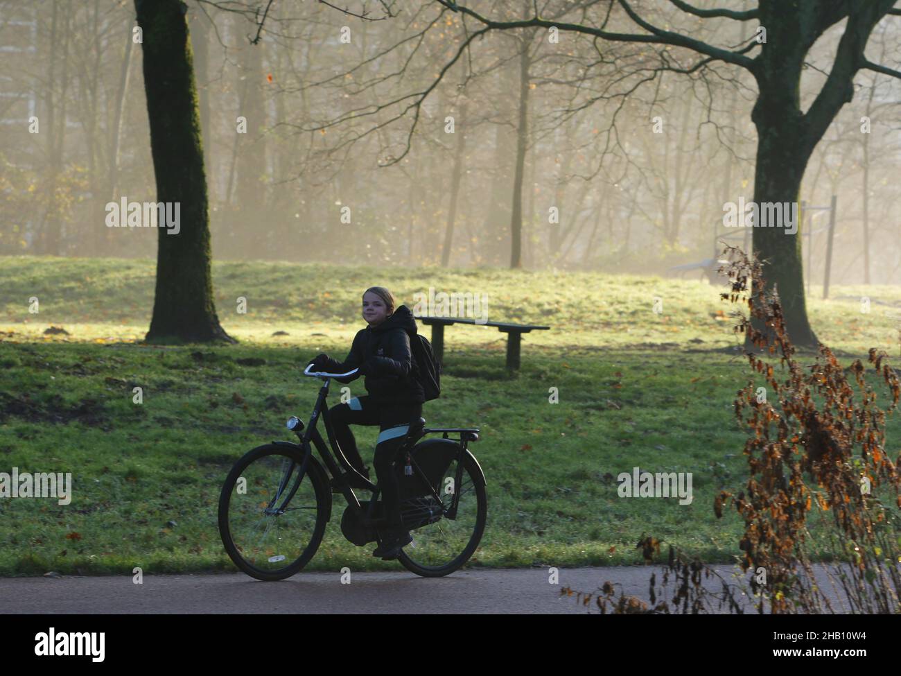 Una giovane ragazza giro in bicicletta di ritorno dalla scuola fanno la  loro strada a casa in mezzo al coronavirus pandemic il 16 dicembre 2021 ad  Amsterdam, Olanda. Amsterdam, Paesi Bassi. Il