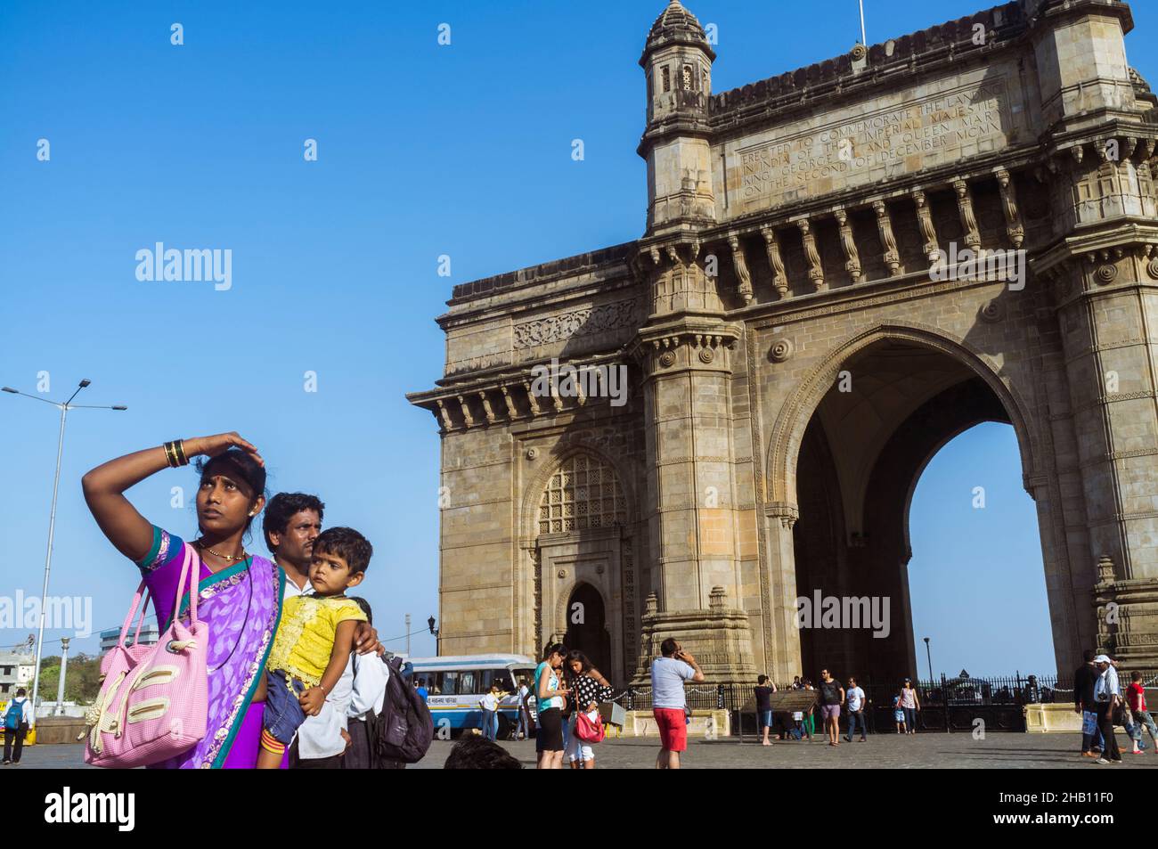 Mumbai, Maharashtra, India : una donna indiana si trova accanto alla porta d'India arco monumentale costruito tra il 1913 e il 1924 nello stilista Indo-Saracenico Foto Stock