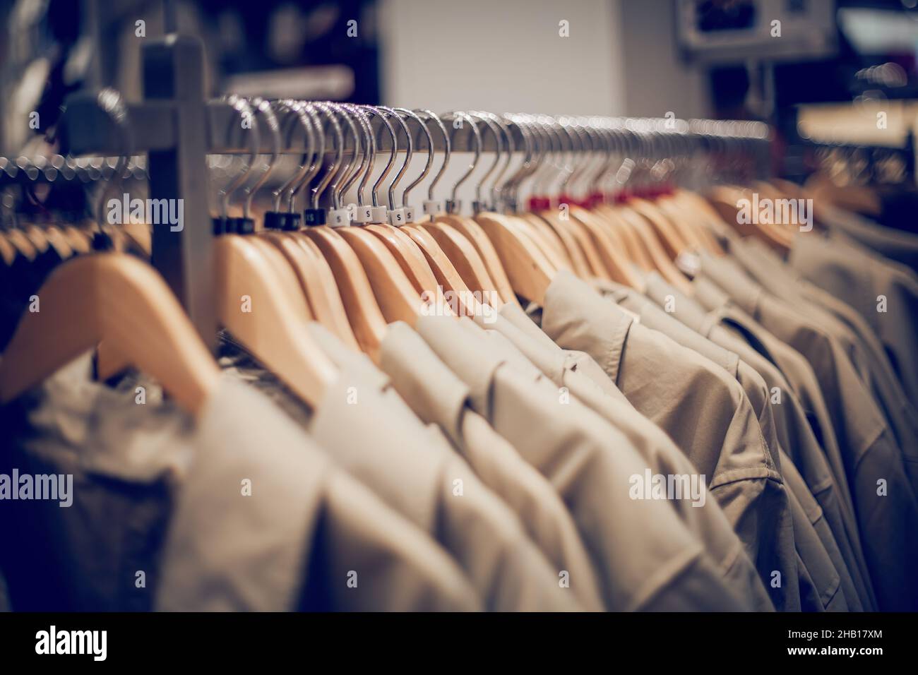 Shopping in negozio. Vestiti su appendiabiti in negozio per la vendita. Sfocatura dello sfondo. Abiti alla moda in una boutique. Vari abbigliamento sul mercato. Foto Stock