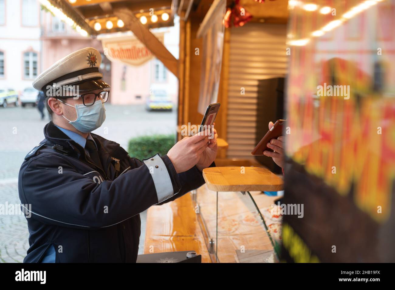 Magonza, Germania. 16th Dic 2021. Un ufficiale di polizia controlla un record di vaccinazione durante un giorno di controllo di conformità nazionale per la pandemia di coronavirus. Credit: Sebastian Gollnow/dpa/Alamy Live News Foto Stock