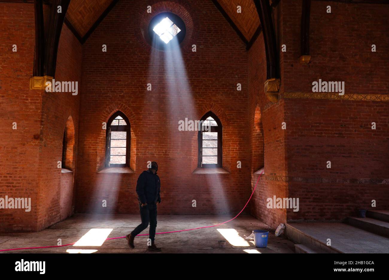 16 dicembre 2021, Srinagar, Jammu e Kashmir, India: Un uomo che guarda alla luce del sole che sbirciava attraverso le finestre della chiesa di St. Lukes, vecchia di 125 anni, che è stata chiusa per più di 30 anni a Srinagar. La pietra di fondazione fu eretta dal Dott. Ernest e dal Dott. Arthur neve, alla Gloria di Dio e come testimone del Kashmir fu dedicata dal Vescovo di Lahore il 12 settembre 1896. Dopo la revoca dello status speciale del Kashmir, i cristiani della regione temono che il cambiamento porterà ad un'ondata di nazionalismo indù e con essa, ad un aumento della persecuzione. (Credit Image: © Adel Abbas/ZUMA Foto Stock