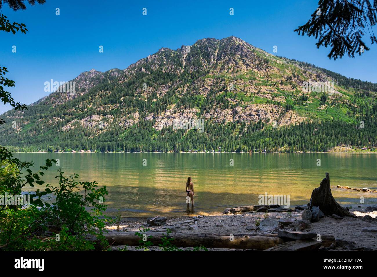 Fit femmina in un bikini in piedi in un lago di montagna Foto Stock