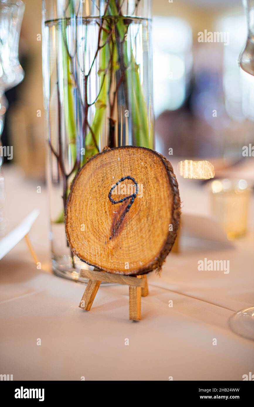 Moncone in legno con numero nove inciso su di esso indicatore di posto di tavolo al tavolo di recetion di nozze Foto Stock