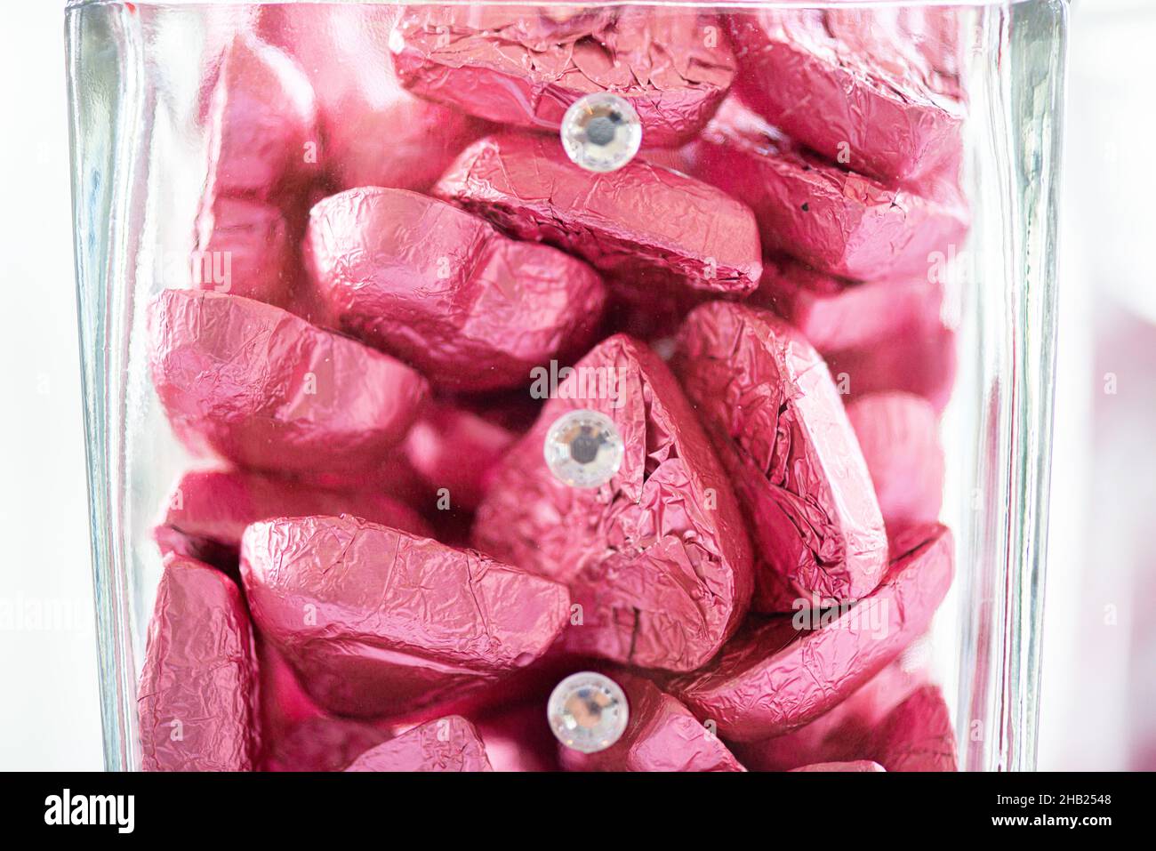 Caramelle al cioccolato a forma di cuore avvolte in foglio di alluminio rosa al bar dessert Foto Stock
