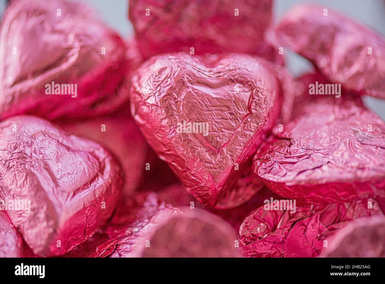 Caramelle al cioccolato a forma di cuore avvolte in foglio di alluminio rosa al bar dessert Foto Stock