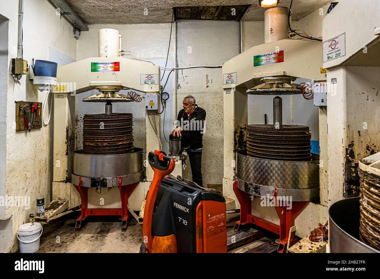 Frantoio tradizionale (Moulin a Huile Traditionnel) a Draguignan, Francia. Quattro presse meccaniche vengono utilizzate contemporaneamente a Fabrice Godet. I tappetini vengono pressati con la pasta d'oliva applicata (Grignon) per circa un'ora Foto Stock