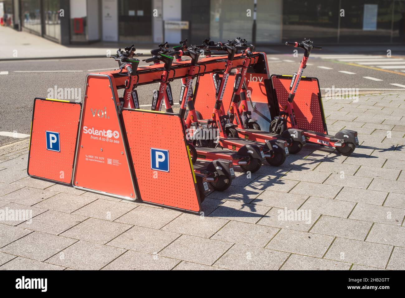 SolentGo voi e-scooters parcheggiati in una rastrelliera designata come parte della prova sperimentale pubblica di noleggio di scooter elettronici a Southampton nel 2021 Foto Stock