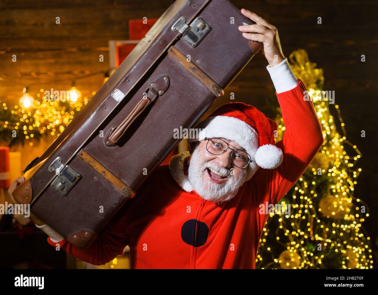 Babbo Natale con valigia. Viaggio di Capodanno. Vacanze invernali. Sfondo di Natale. Servizio di consegna. Foto Stock