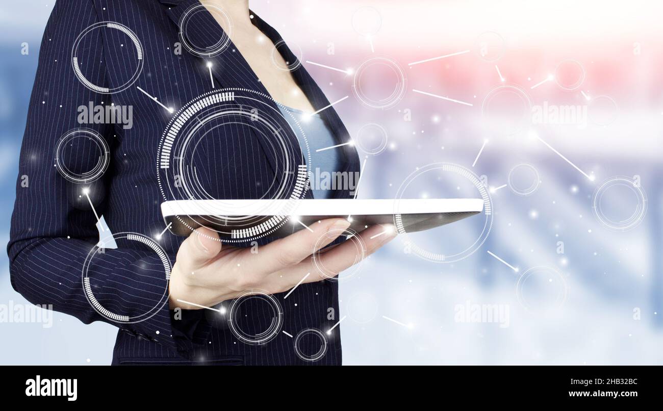 Concetto di tecnologia di innovazione e comunicazione delle reti aziendali. Tenere la compressa bianca con ologramma digitale diagramma circolare segno su luce sfocata Foto Stock