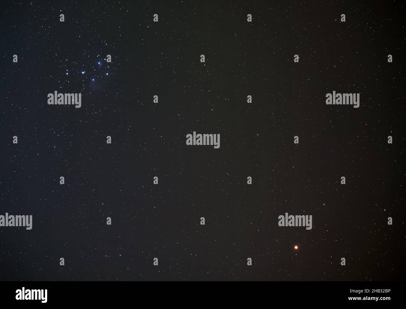 Pleiades (conosciuto anche come Seven Sisters) open star cluster sul cielo notturno invernale, luminoso pianeta rosso Marte in basso a destra, foto a lunga esposizione Foto Stock
