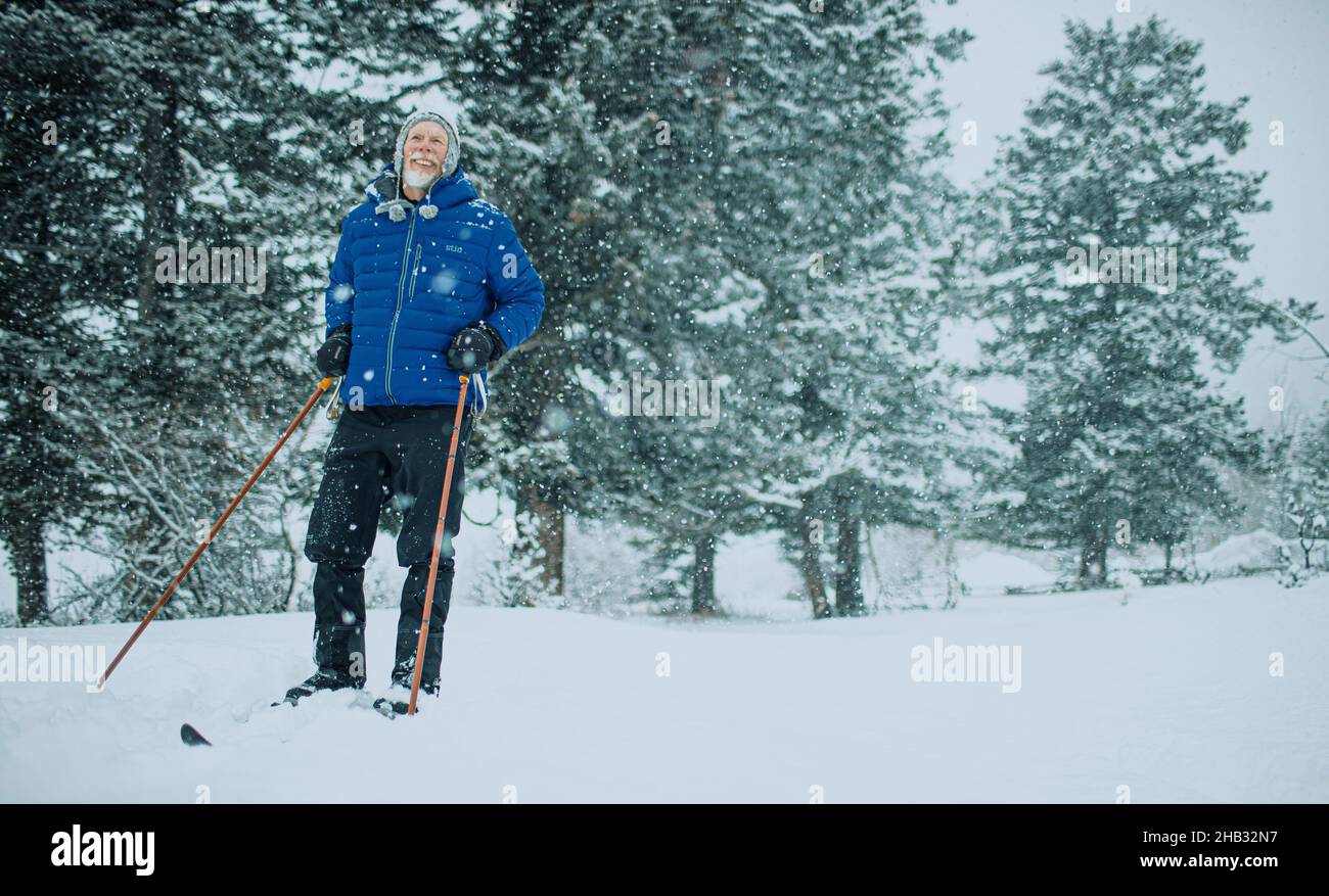 Sci di fondo uomo anziano in una giornata nevosa Foto Stock