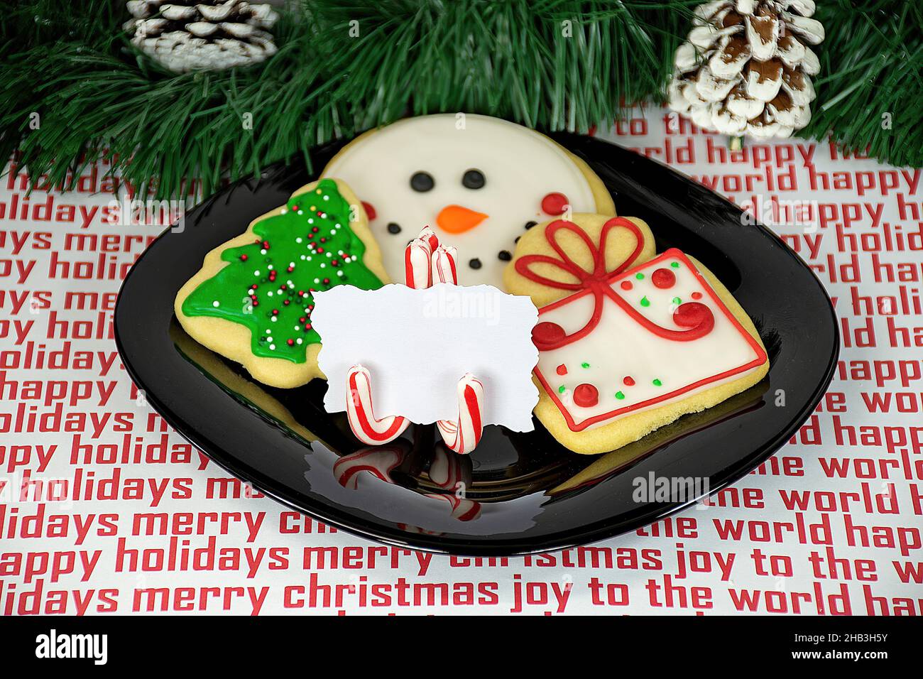 Biscotti di zucchero di Natale con la canna di caramella mettere il porta carte su piatto nero Foto Stock