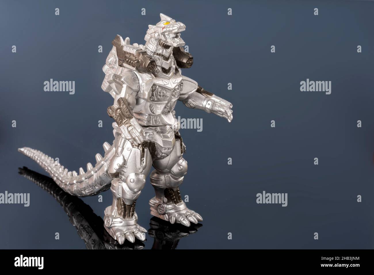 Un giocattolo di lucertola metallizzato d'argento. Leggendario mostro asiatico. Una mascotte gigante. Creatura plastica in dettaglio sulla superficie riflettente. Oggetto culturale Foto Stock