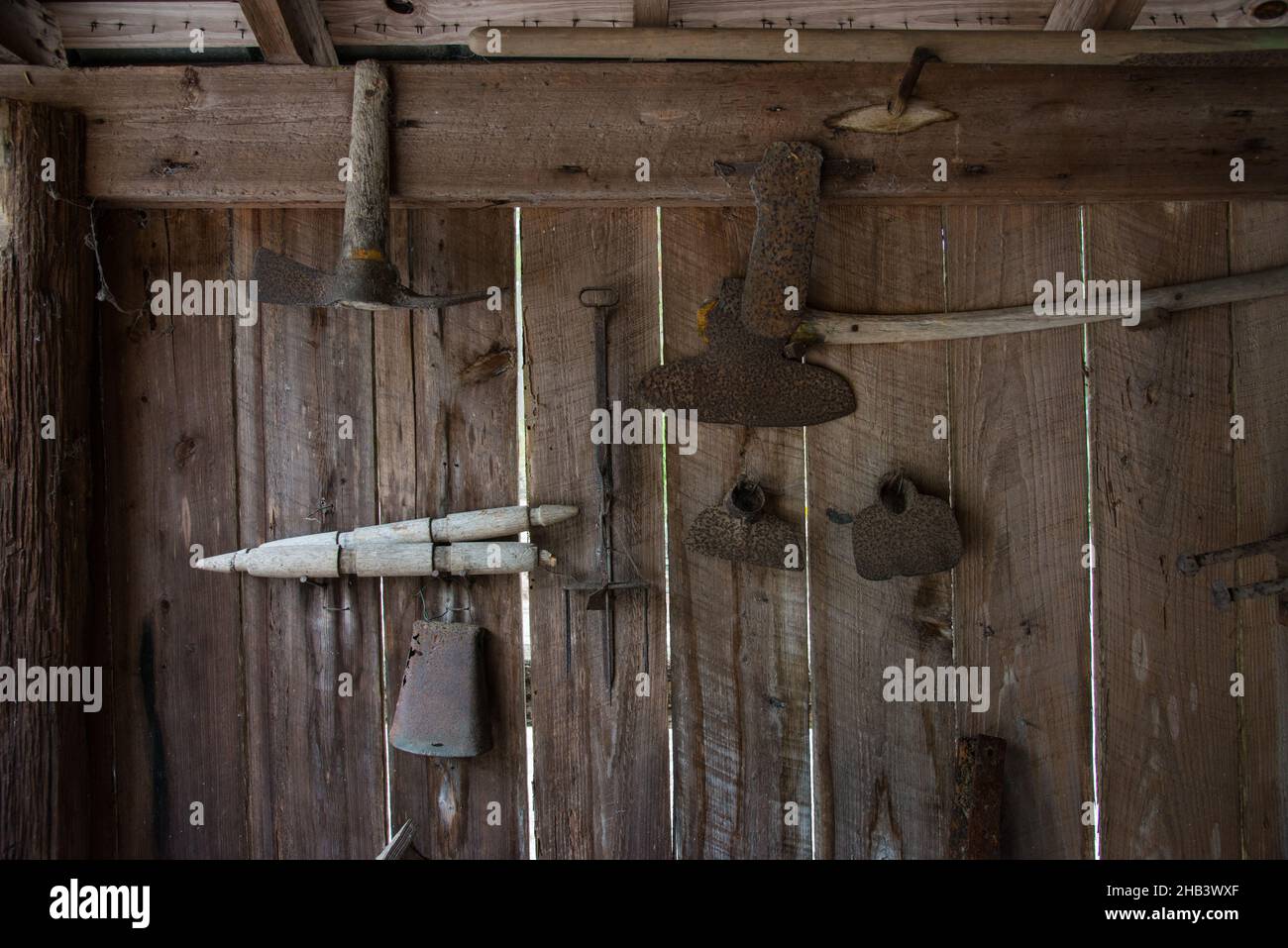 Vecchi strumenti appeso alla parete in officina, ripiano porta attrezzi  contro un muro in garage Foto stock - Alamy