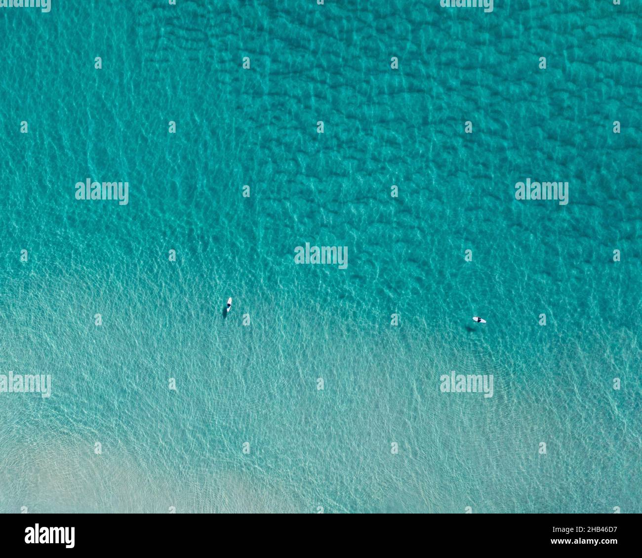 Bella vista aerea di acqua incontaminata blu con surfisti e dolci onde Foto Stock