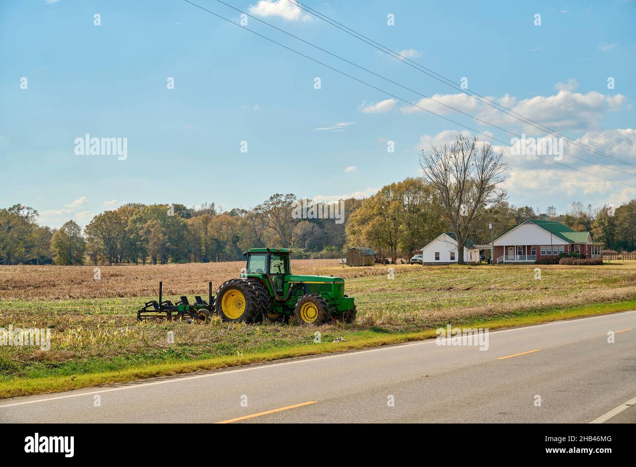 Piccola azienda agricola americana a conduzione familiare con trattore John Deere e timone con la fattoria sullo sfondo in Alabama rurale, USA. Foto Stock