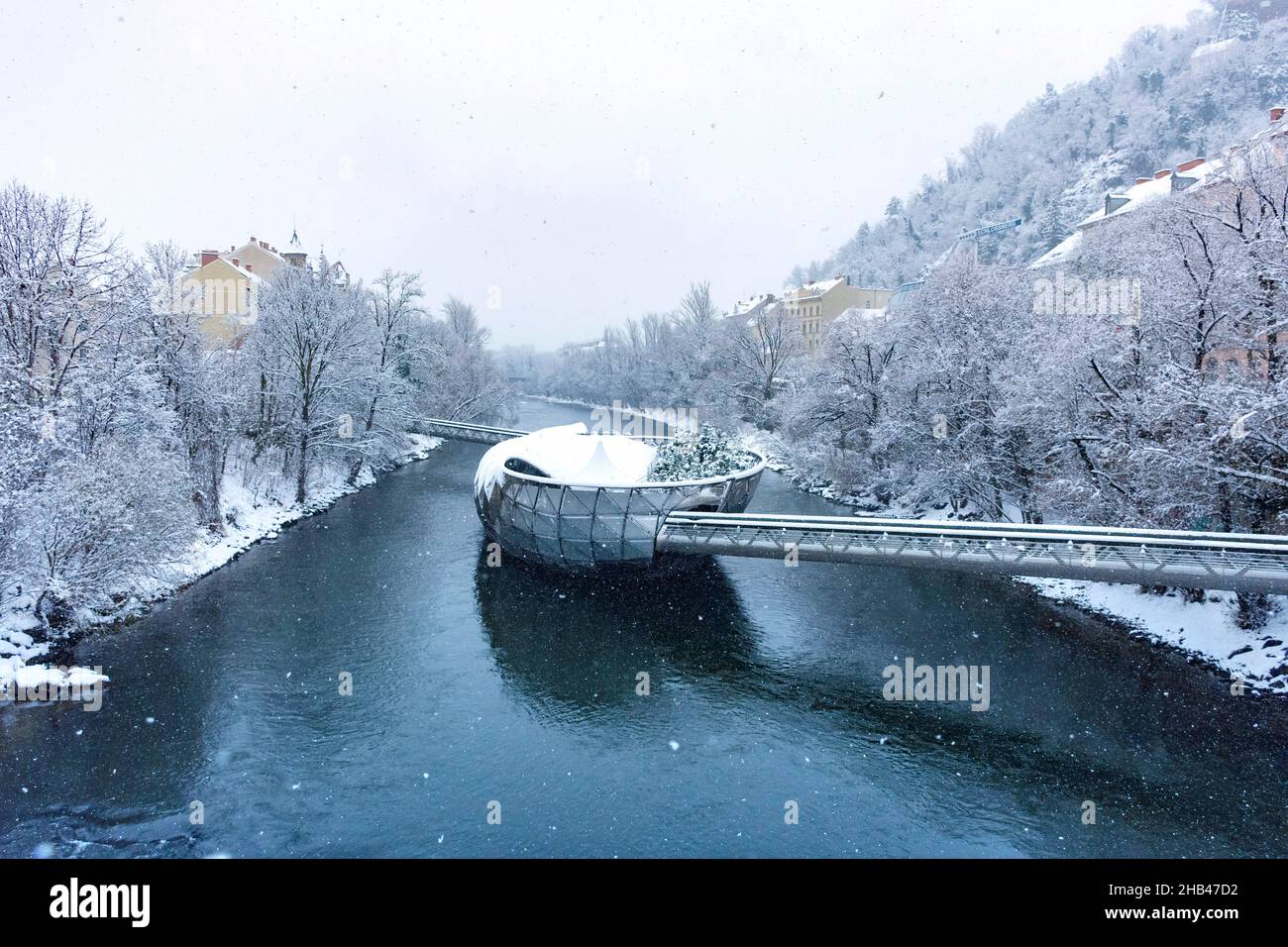 Fiume Mur con ponte Murinsel a Graz, regione Steiermark, Austria, con neve, in inverno Foto Stock