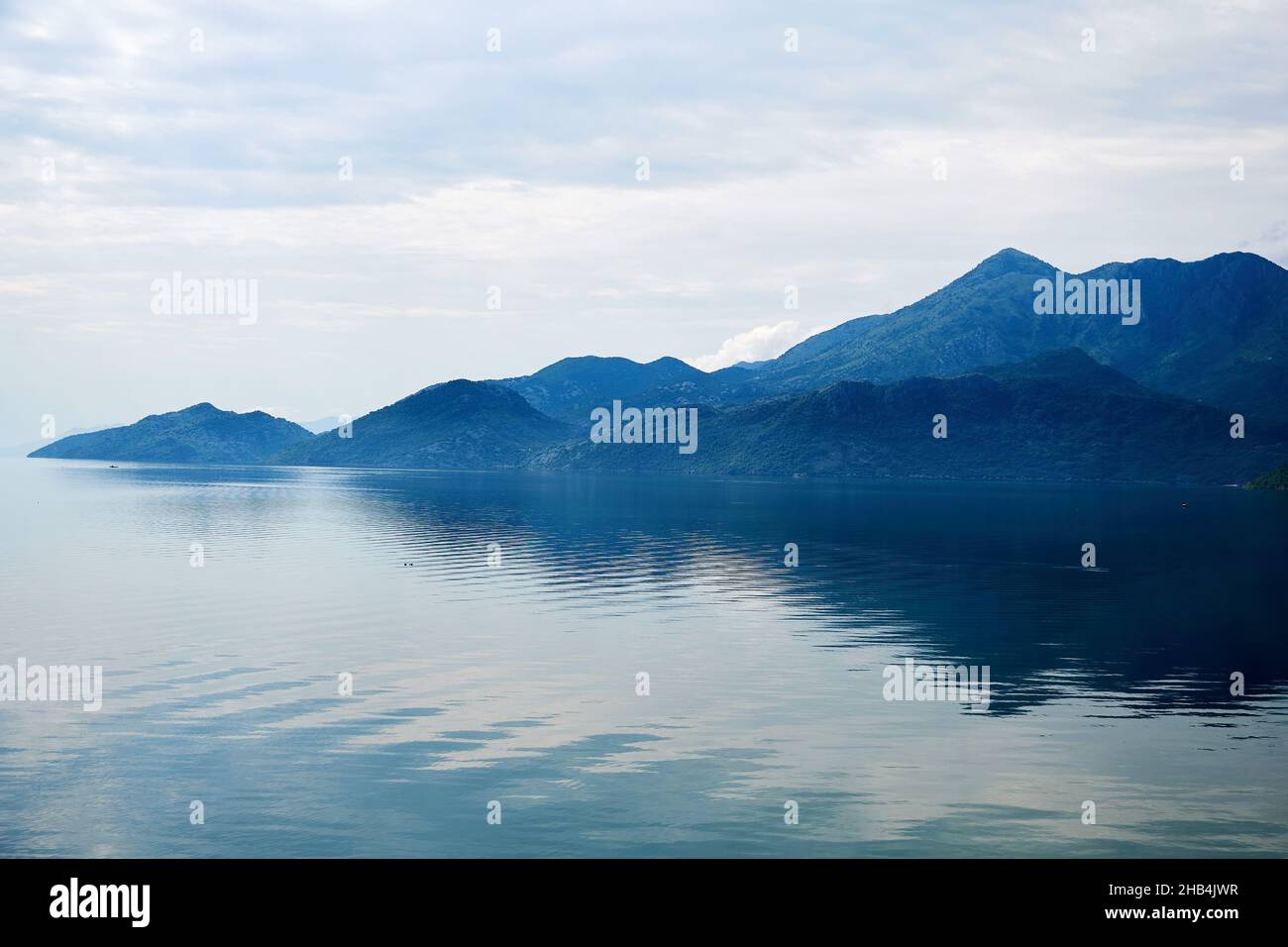 Tranquillo lago blu sul bordo della catena montuosa. Scenografici sfondi naturali Foto Stock