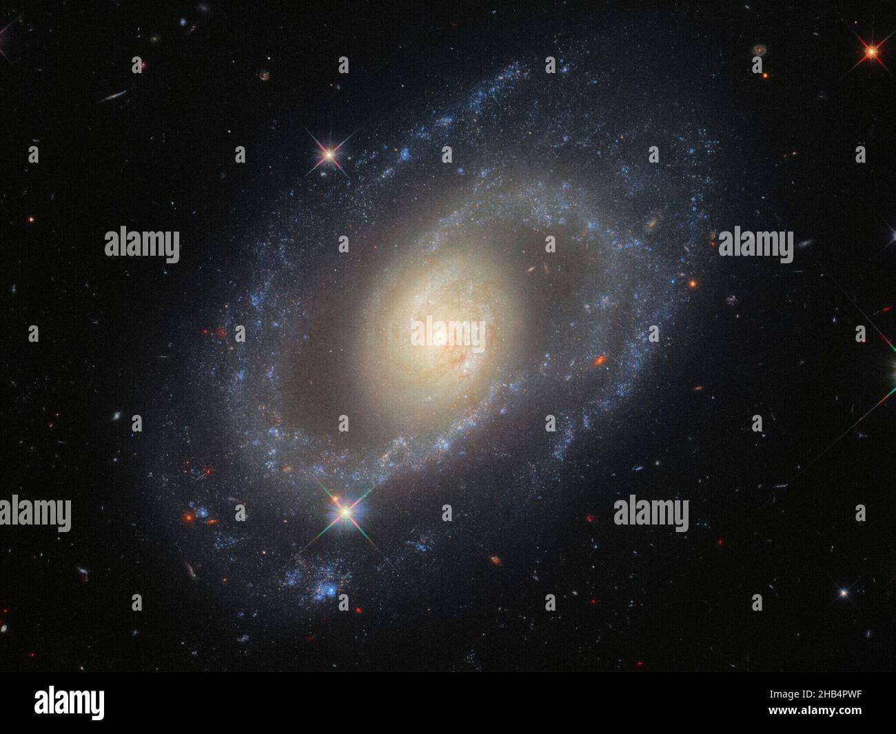 Questa immagine del telescopio spaziale Hubble della NASA/ESA presenta la galassia a spirale MRK 1337, che è a circa 120 milioni di anni luce dalla Terra nella costellazione di Virgo. La telecamera a campo largo 3 Hubbles ha scattato MRK 1337 ad un'ampia gamma di lunghezze d'onda ultraviolette, visibili e infrarosse, producendo questa immagine riccamente dettagliata. MRK 1337 è una galassia a spirale debolmente barrata, che come suggerisce il nome significa che le braccia a spirale irradiano da una barra centrale di gas e stelle. Le sbarre si presentano in circa la metà delle galassie a spirale, inclusa la nostra galassia la Via Lattea. Queste osservazioni fanno parte di una campagna per im Foto Stock