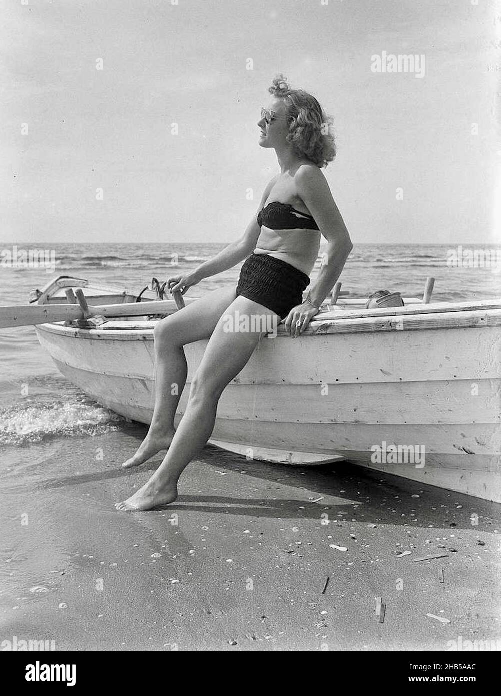 Summer Pictures-at-Beach-of-Zandvoort - modello in posa accanto a una barca a remi Foto Stock