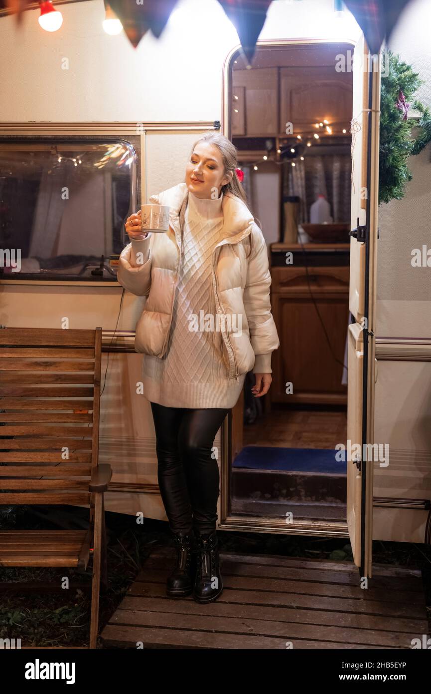 bella ragazza candida in piena altezza godimento rilassante tazza di caffè o tè o bevanda al cacao in mano tenendo felice anno nuovo e vigilia di natale Foto Stock